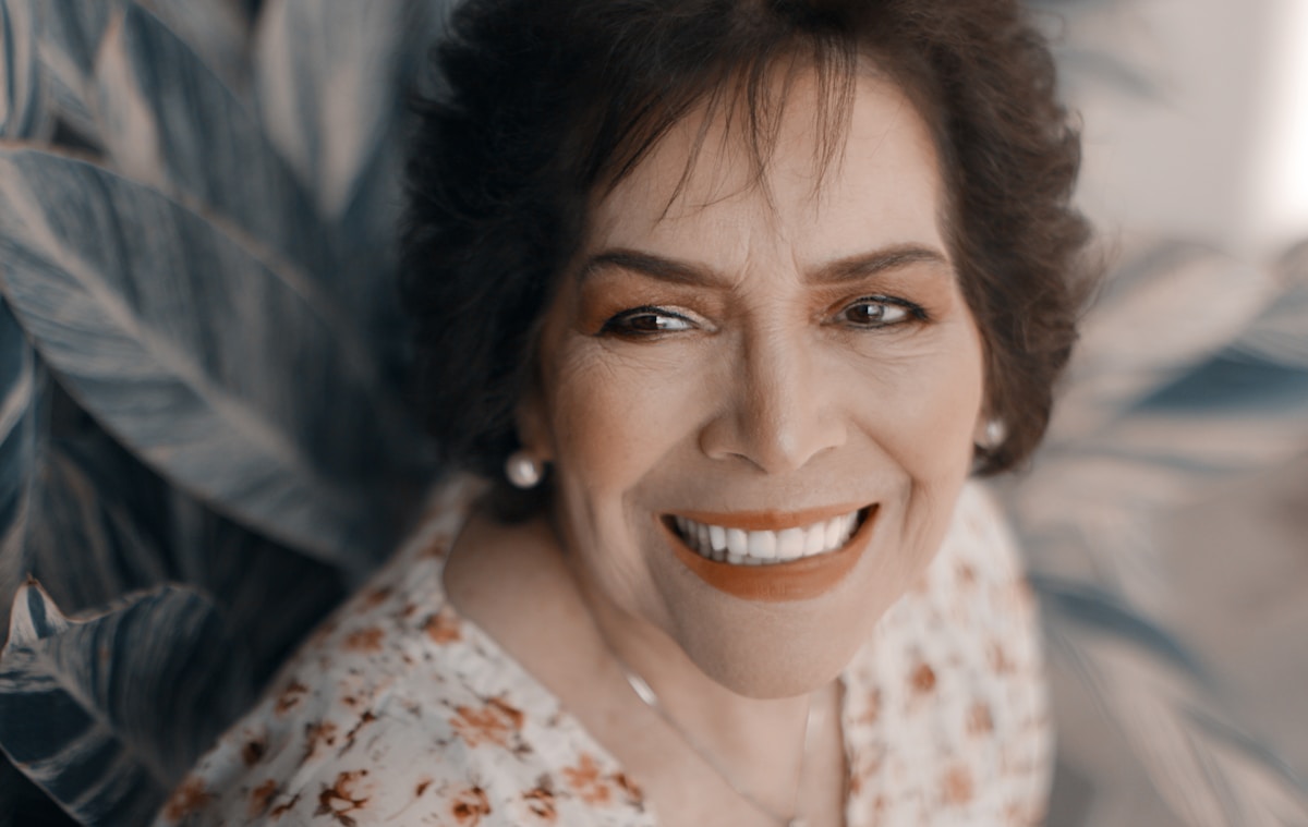 Participante sorrindo, sendo recebida com carinho em um encontro do Vida Lá Fora
