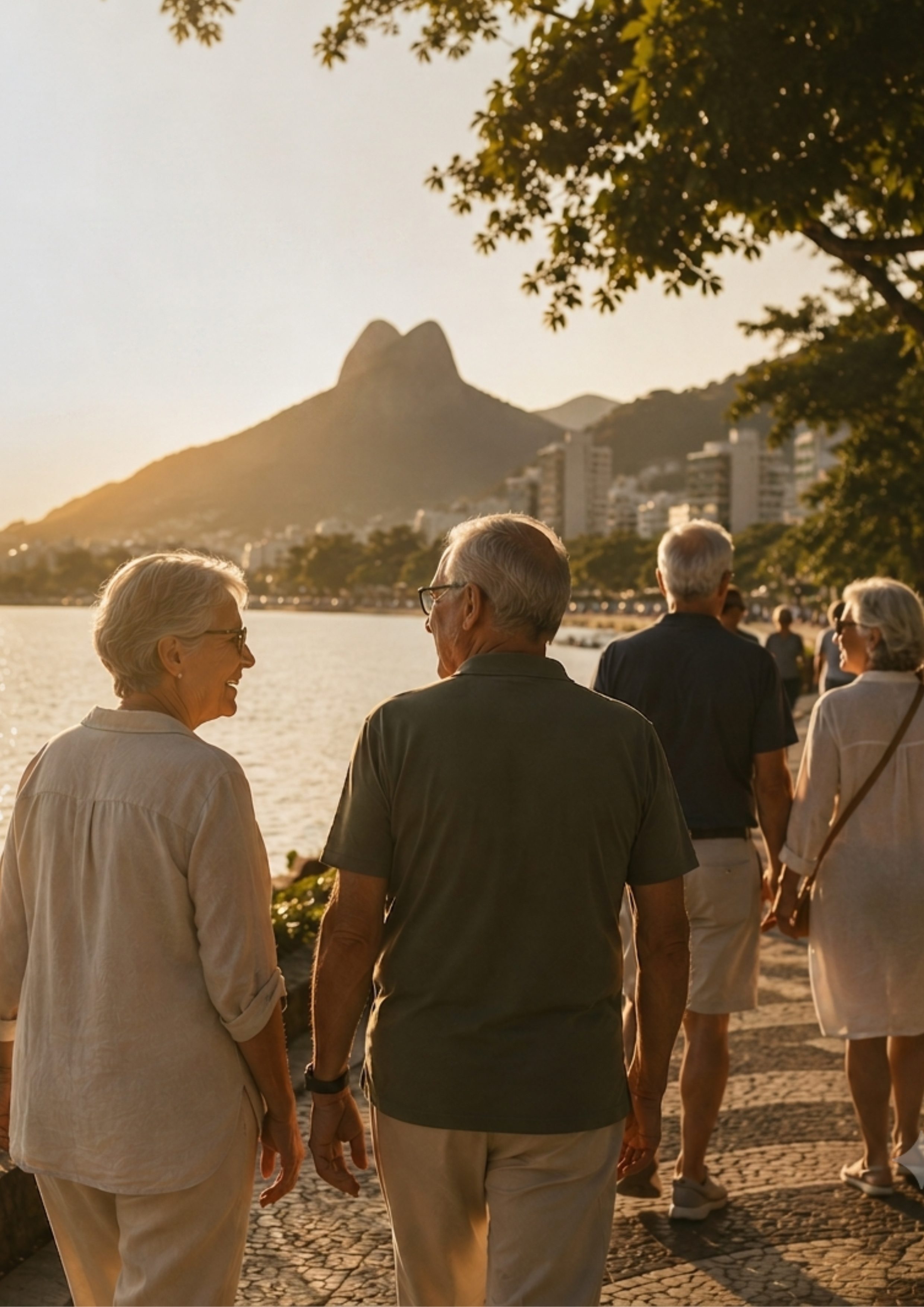 Grupo de pessoas 50+ caminhando e conversando à beira da Lagoa Rodrigo de Freitas, Rio de Janeiro, ao entardecer